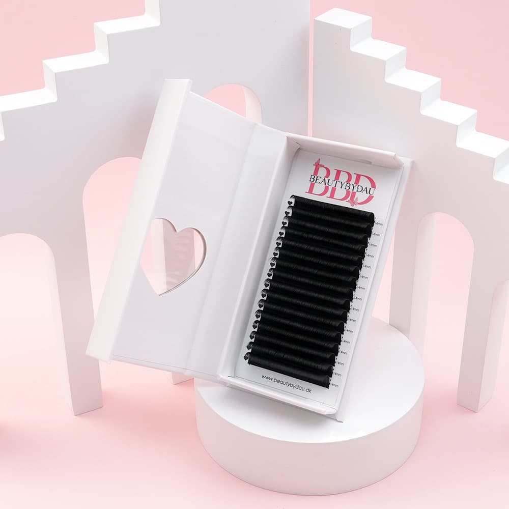 Åbnet vippe bakke med volume lashes inden i og et lyserødt baggrund med en hvid trappe